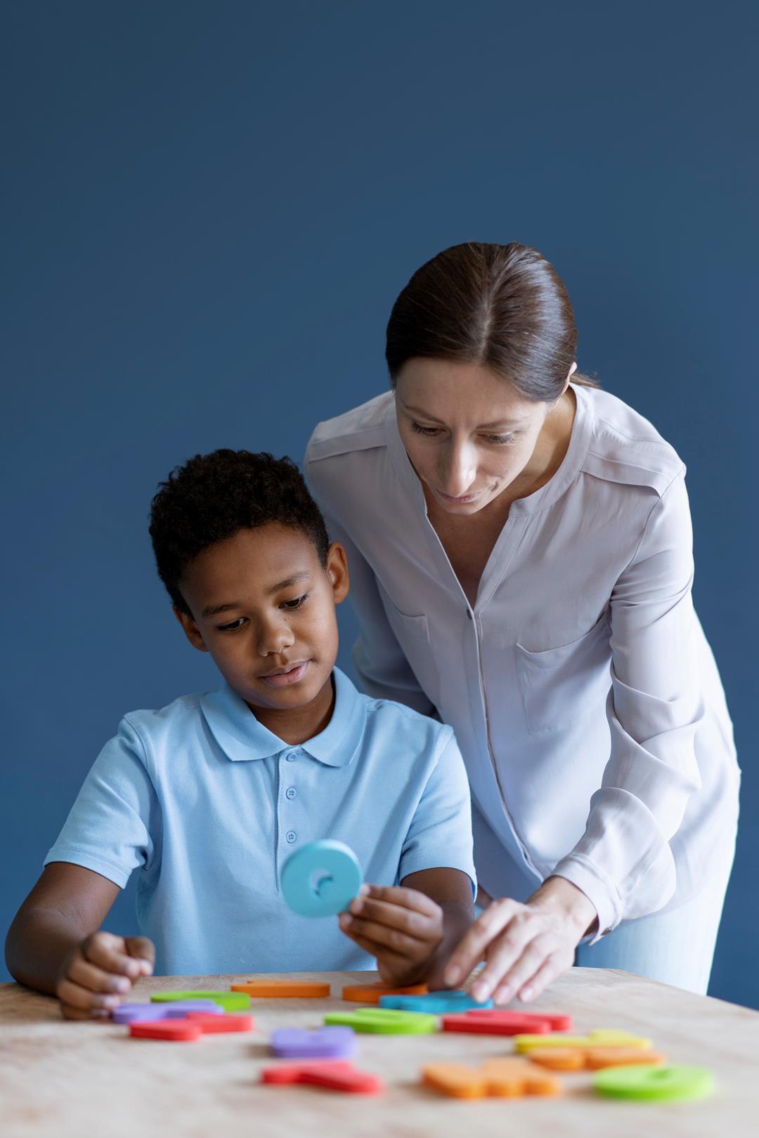 Occupational therapist supporting motor planning and regulation in a child with autism and whole-body apraxia.