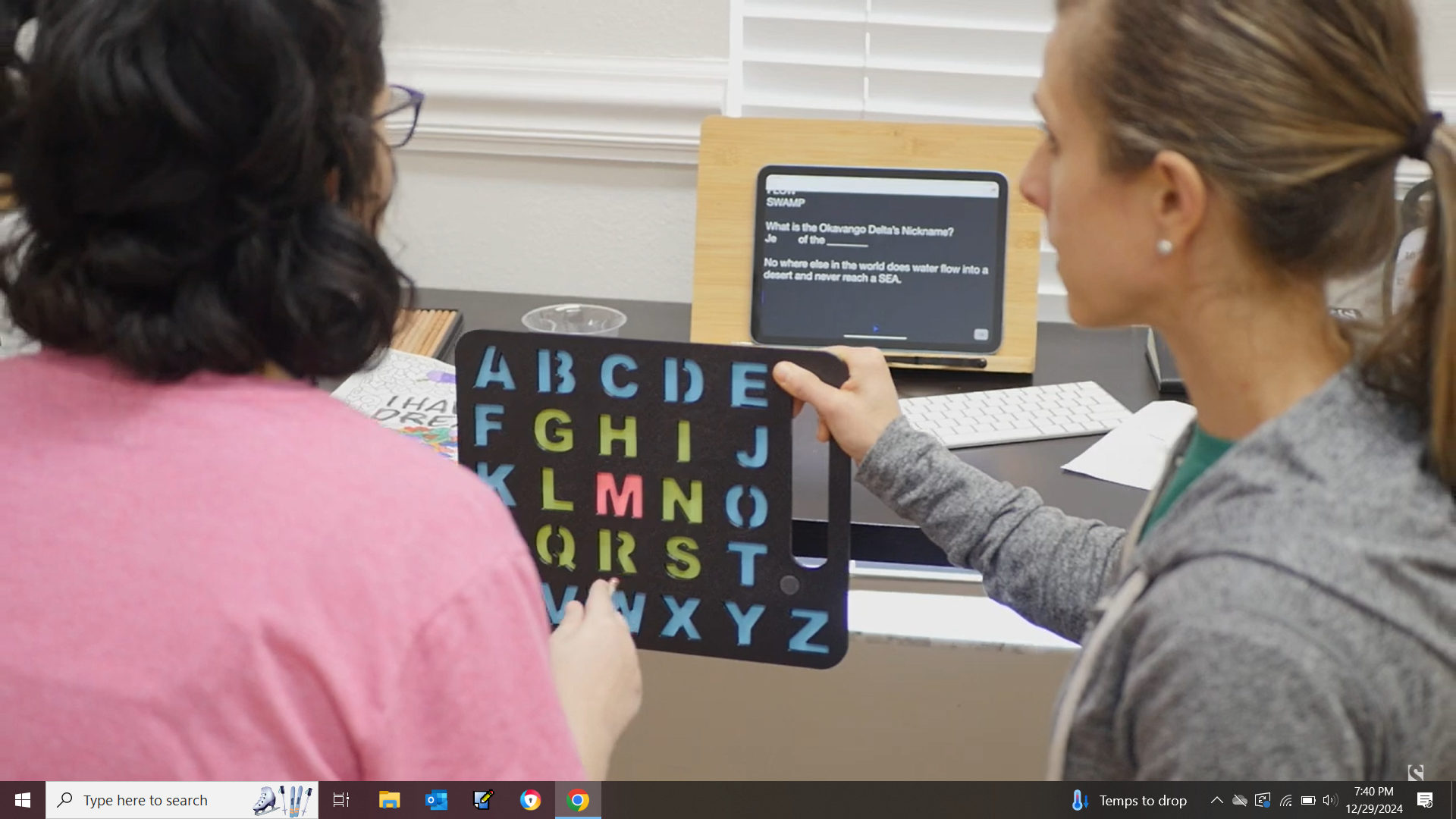 Parent supporting a nonspeaking child using a letterboard to spell